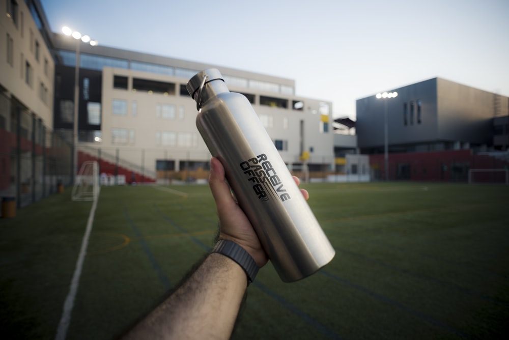 person holding stainless steel vacuum flask