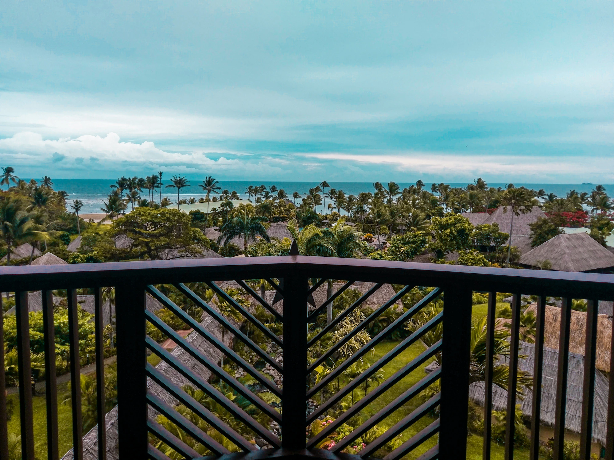Balcón de un apartamento frente a una playa caribeña con palmeras