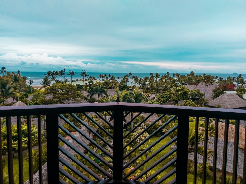 wide-angle photography of brown huts surrounded by coconut palm trees during daytime