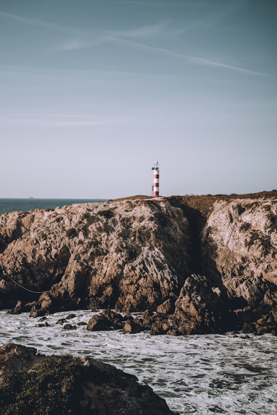 white and red lighthouse in Porto Covo Portugal