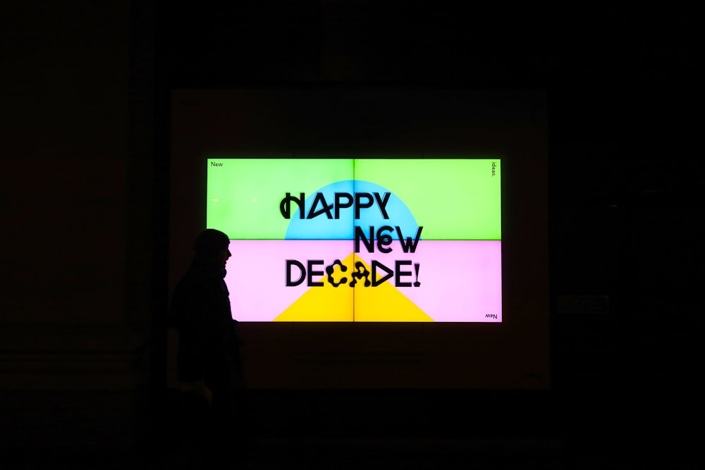 silhouette of standing person standing beside monitor