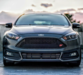 A sleek 2018 Ford Focus parked against a vibrant Tampa skyline at sunset.