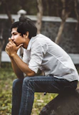 man sitting on black boulder