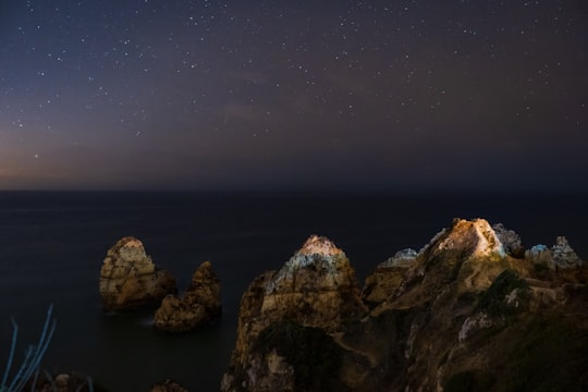 brown rocky mountain under starry sky in Lagos Portugal
