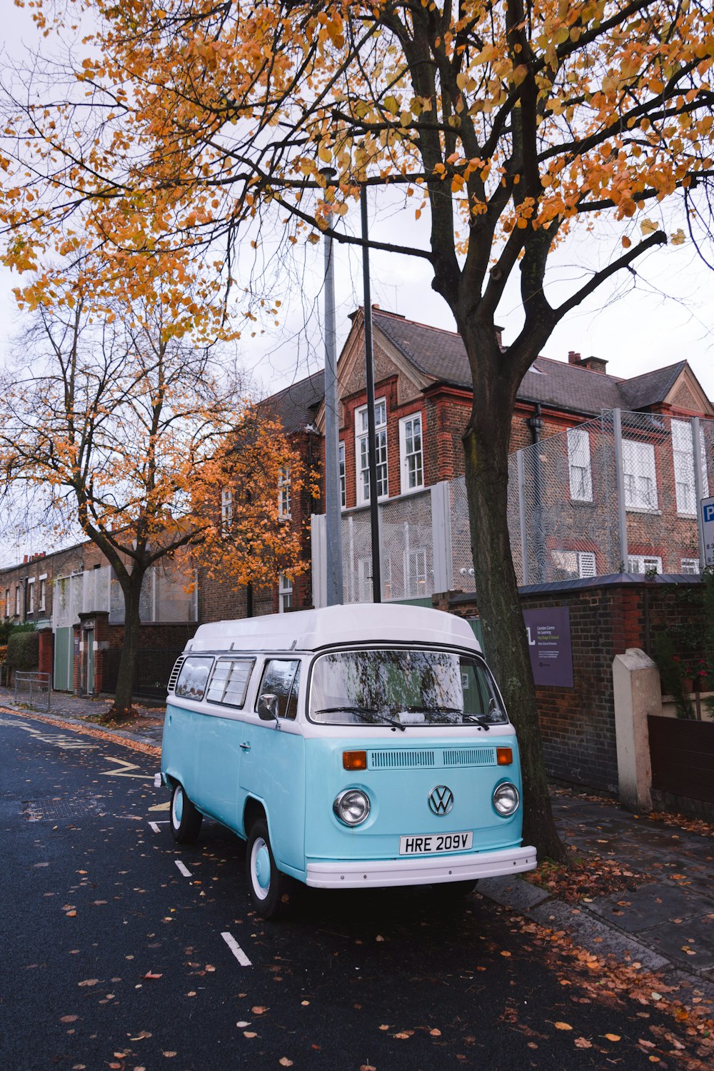 teal Volkswagen Transporter parked beside curb