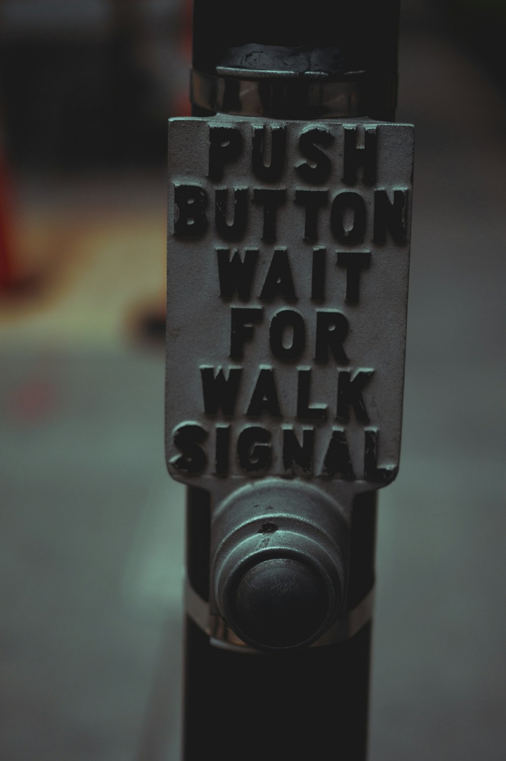 푸시 버튼이라는 단어가 있는 주차 미터기의 클로즈업은 보행 신호를 기다립니다.