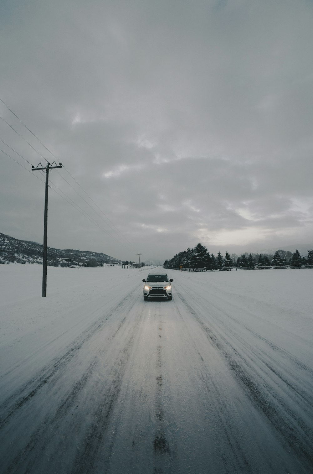 weißes Fahrzeug auf schneebedeckter Straße