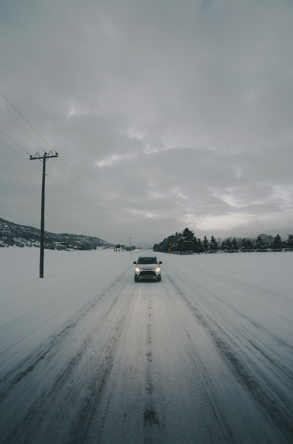 white vehicle on road covered with snow