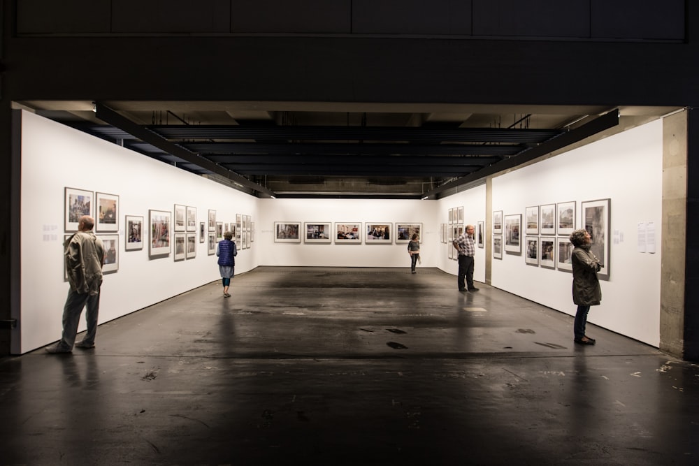 people standnig in front of paintings