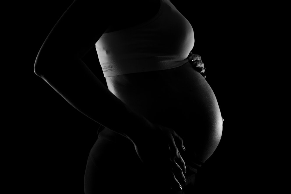 a black and white photo of a pregnant woman