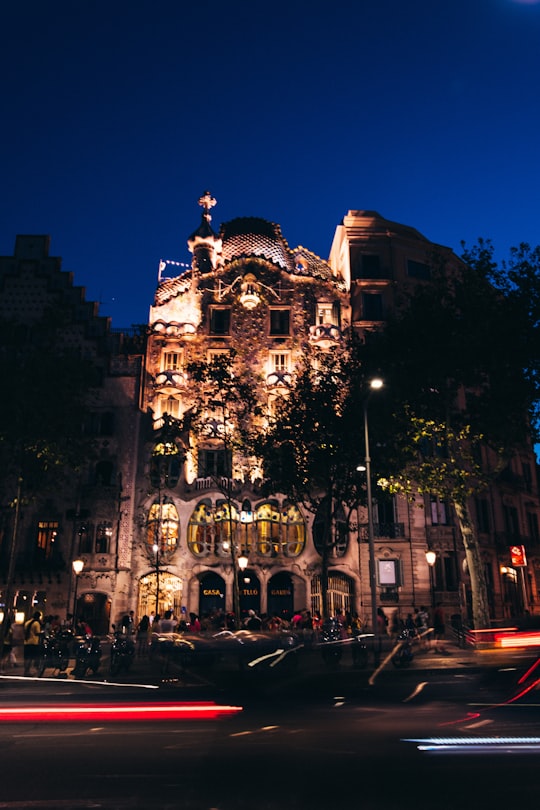 vehicles passing on brown concrete building at night in Casa Batlló Spain