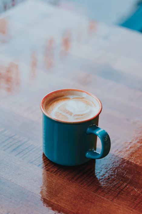 A cozy ceramic mug with a warm latte on a wooden table
