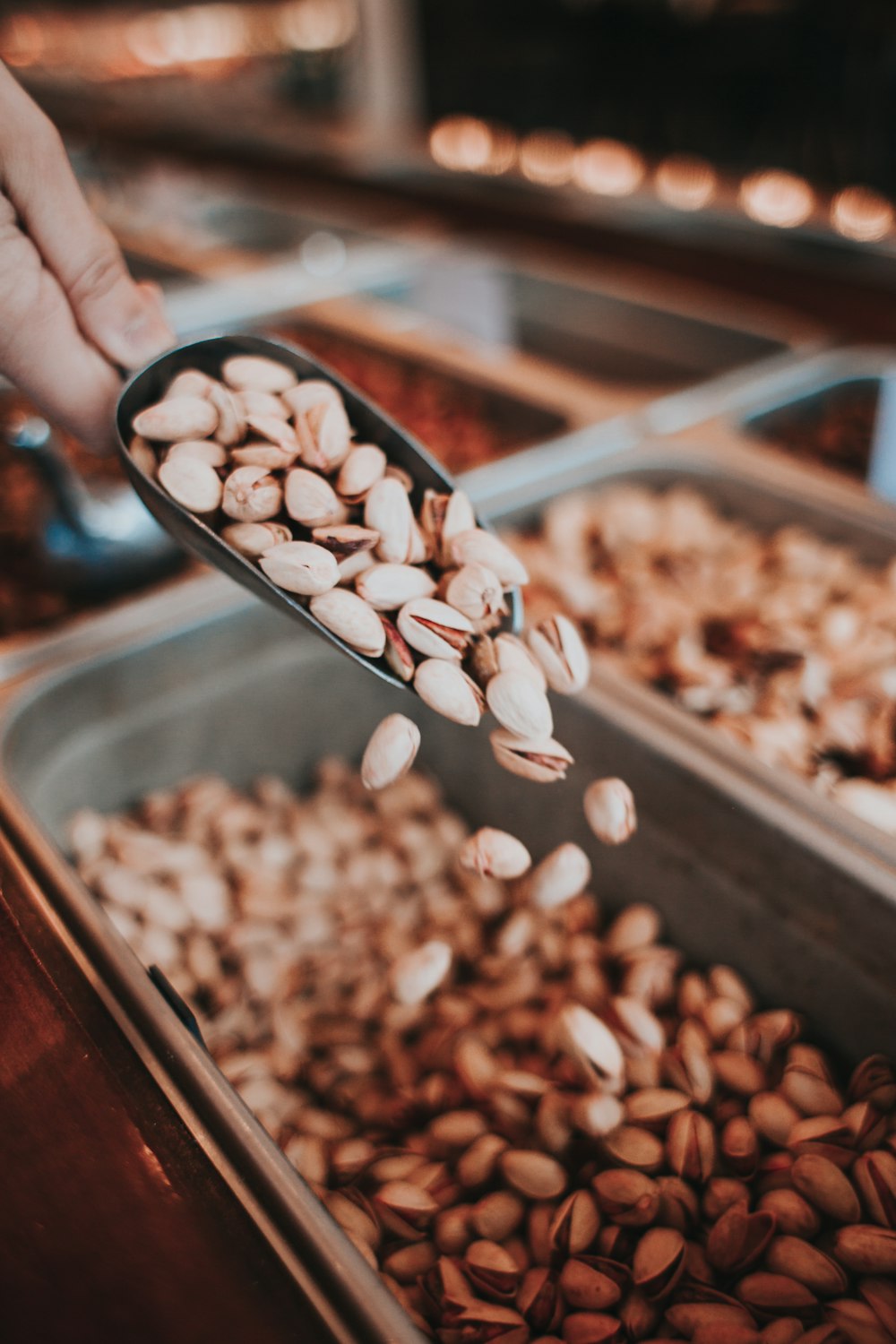 person pouring nuts on panel