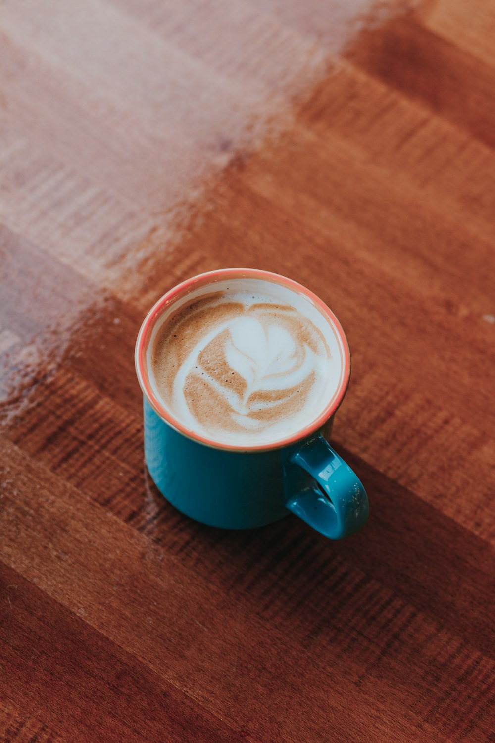 blue ceramic mug on brown wooden surface