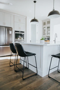 Modern pendant lamps with brushed metal finishes suspended over a stylish kitchen island.