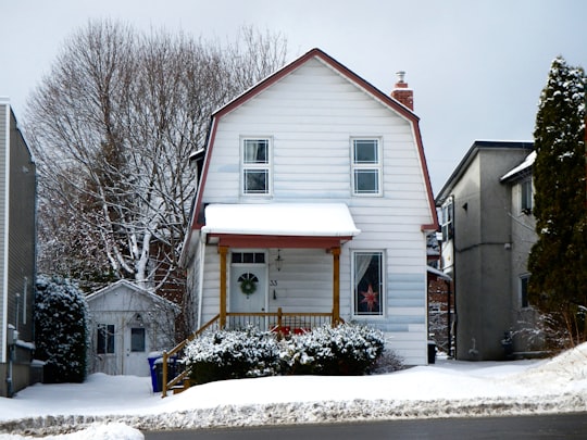 white and brown wooden house near bare trees during daytime in Gatineau Canada