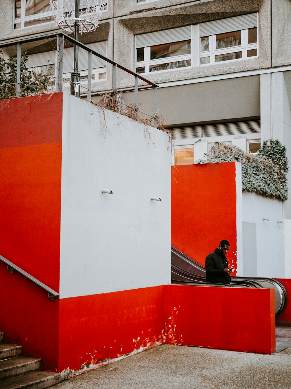 Persona de pie junto a la escalera mecánica durante el día