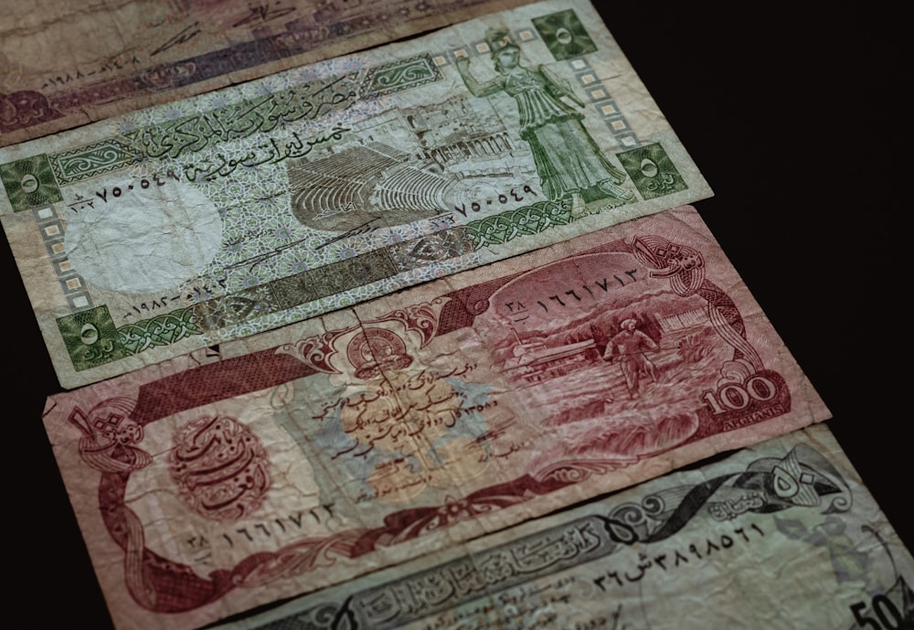 three banknotes on brown surface
