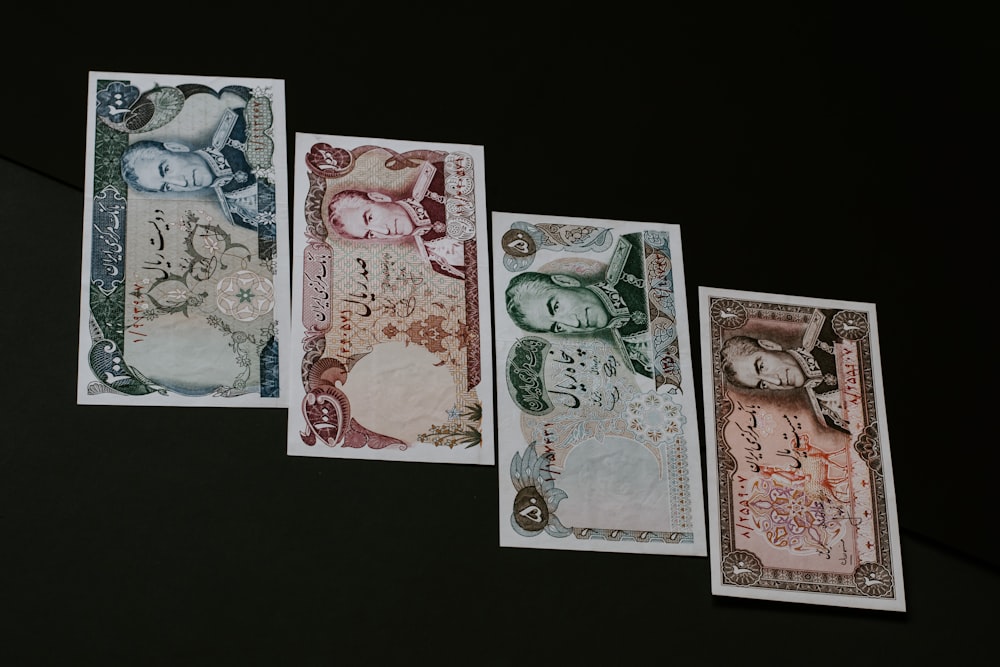 four banknotes on black surface