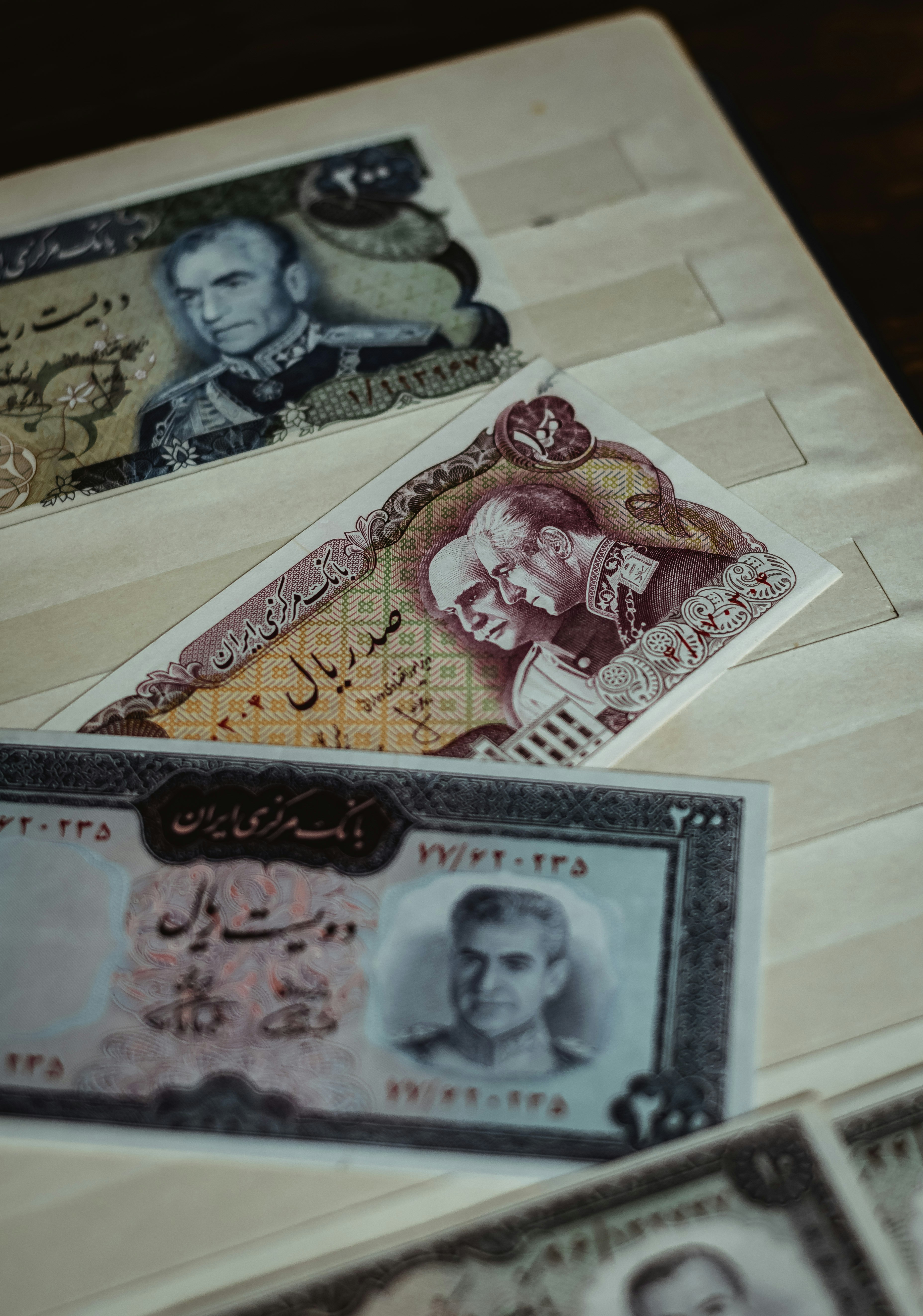 Former bills of Iran's Rial with the pictures of Reza Shah and Mohammad Reza Shah on them. Both the father and the son are pictured in their older ages.