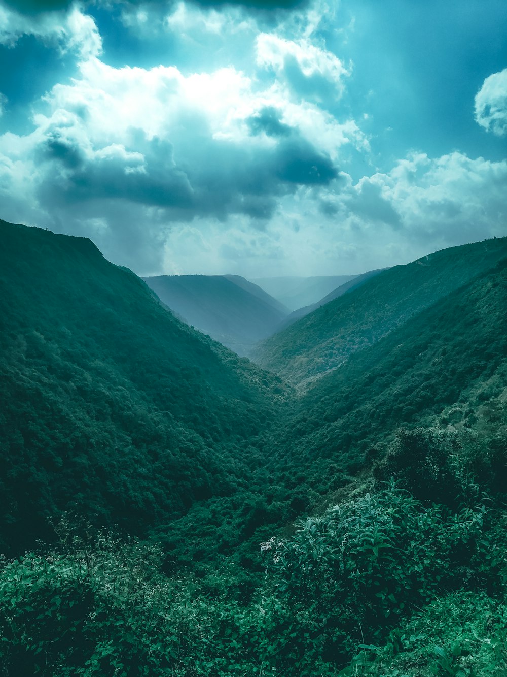 green mountain under white clouds and blue sky during daytime