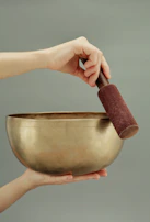 person holding brown clay pot