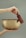 Close-up of gentle hands holding a softly glowing Himalayan singing bowl.