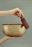 A close-up of a handcrafted singing bowl resting on a soft cushion, bathed in warm natural light.