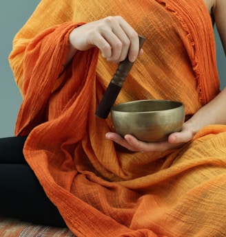 person in orange scarf holding silver round bowl
