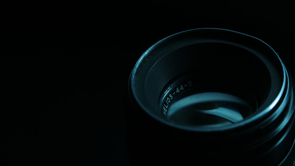 schwarzes Kameraobjektiv auf schwarzer Oberfläche