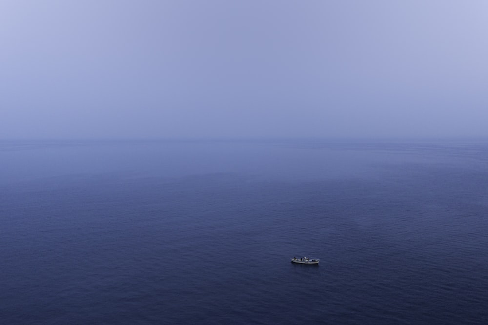 white boat on blue sea under blue sky during daytime