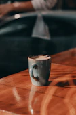 A cozy blue ceramic mug filled with steaming coffee on a wooden table.