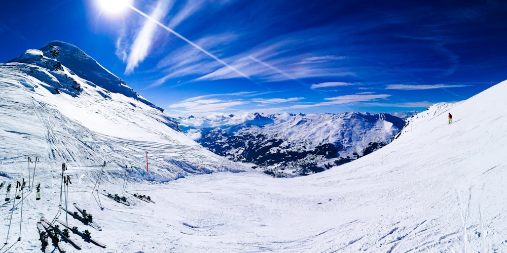 person in red jacket and blue pants standing on snow covered ground during daytime