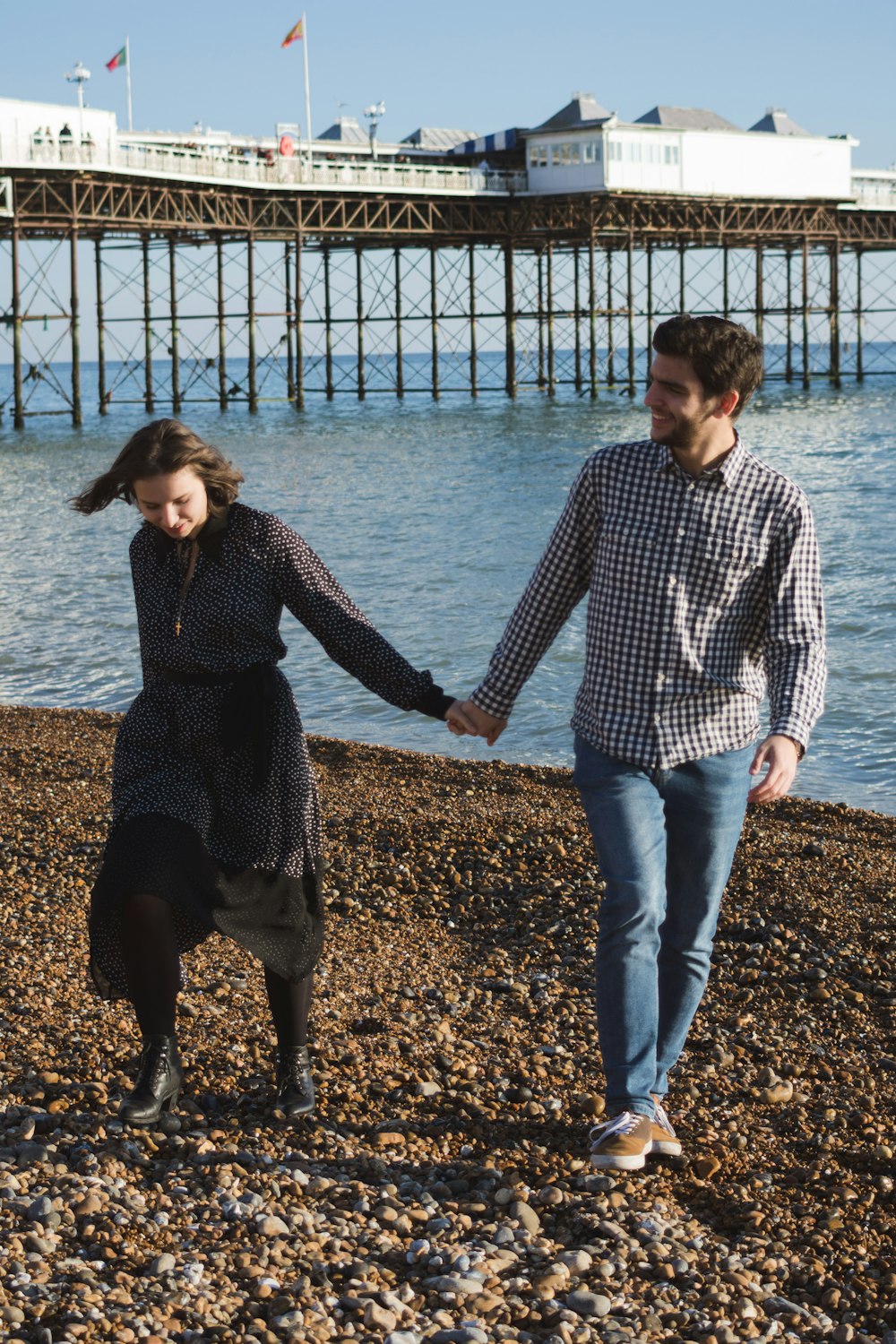 man and woman standing near beach line