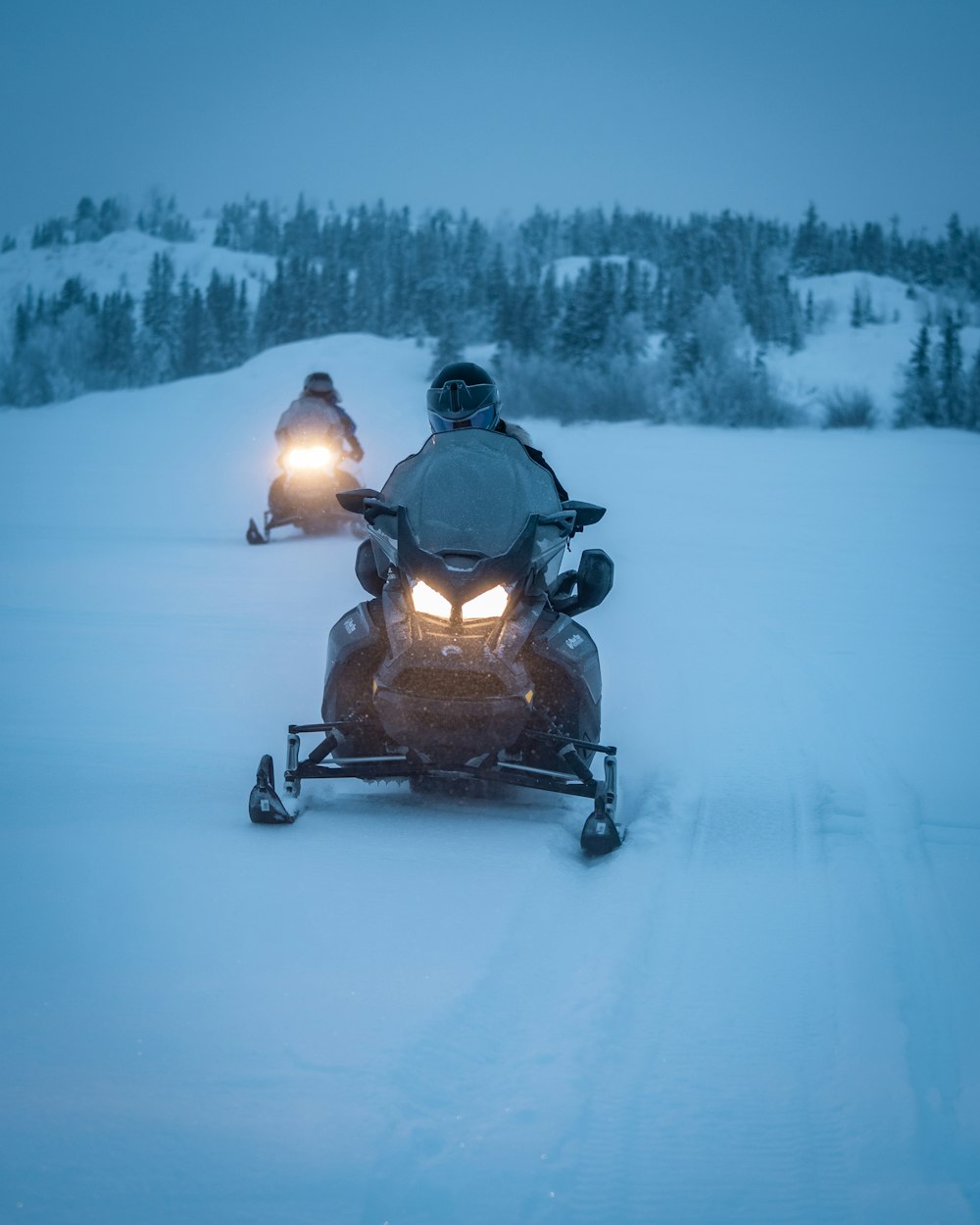 Dos personas en moto de nieve
