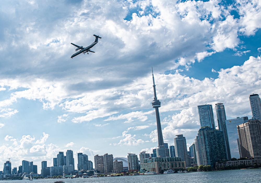 airplane flying over city buildings during daytime