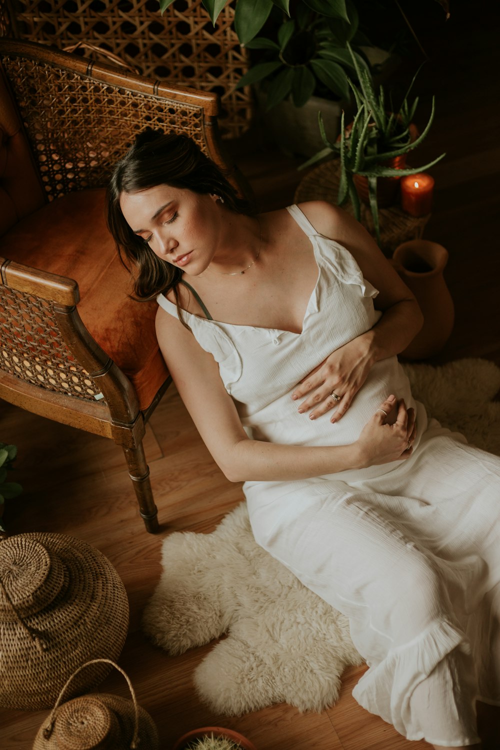 woman in white top leaning beside chair