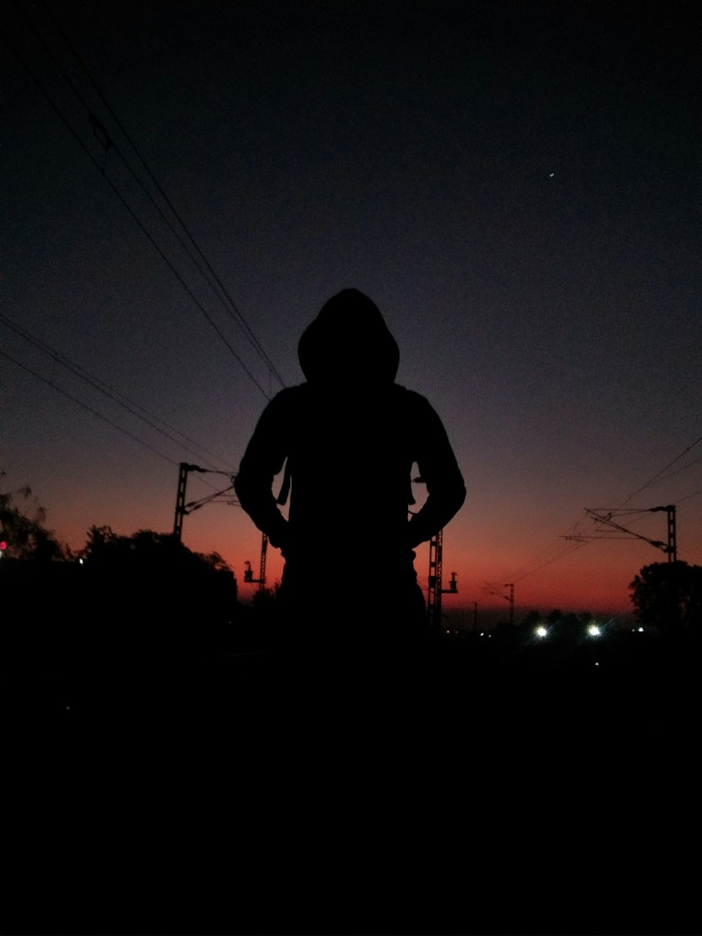 silhouette of man standing on the ground during night time