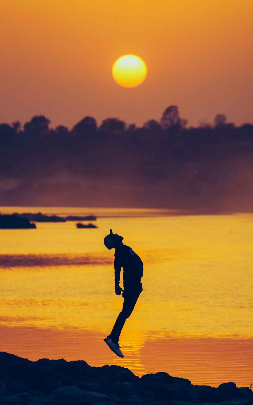 silhouette of man walking on beach during sunset