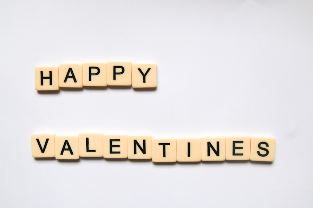 two scrabble tiles spelling happy valentine's day
