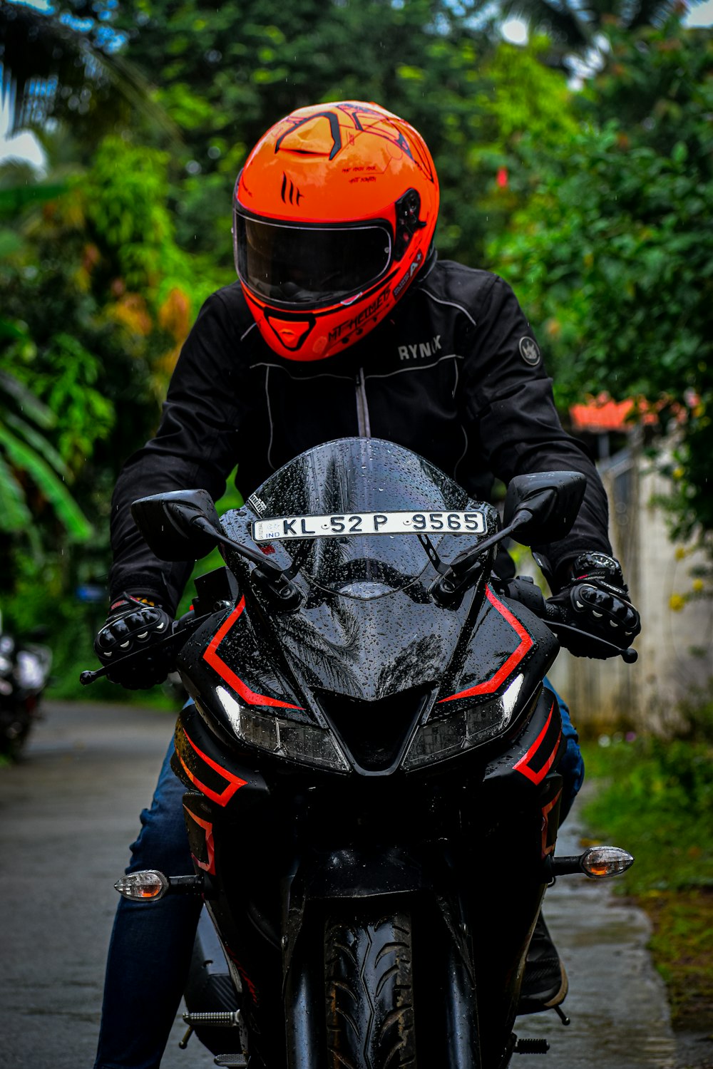 Person mit schwarz-rotem Motorradhelm und schwarzer Jacke