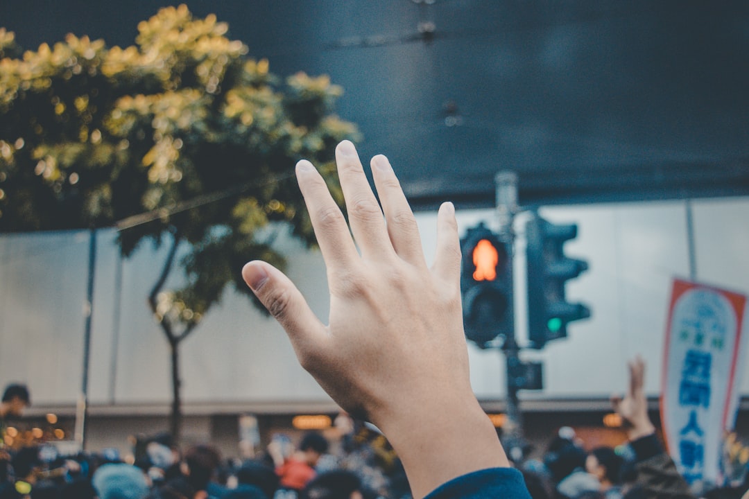 person in blue long sleeve shirt raising right hand