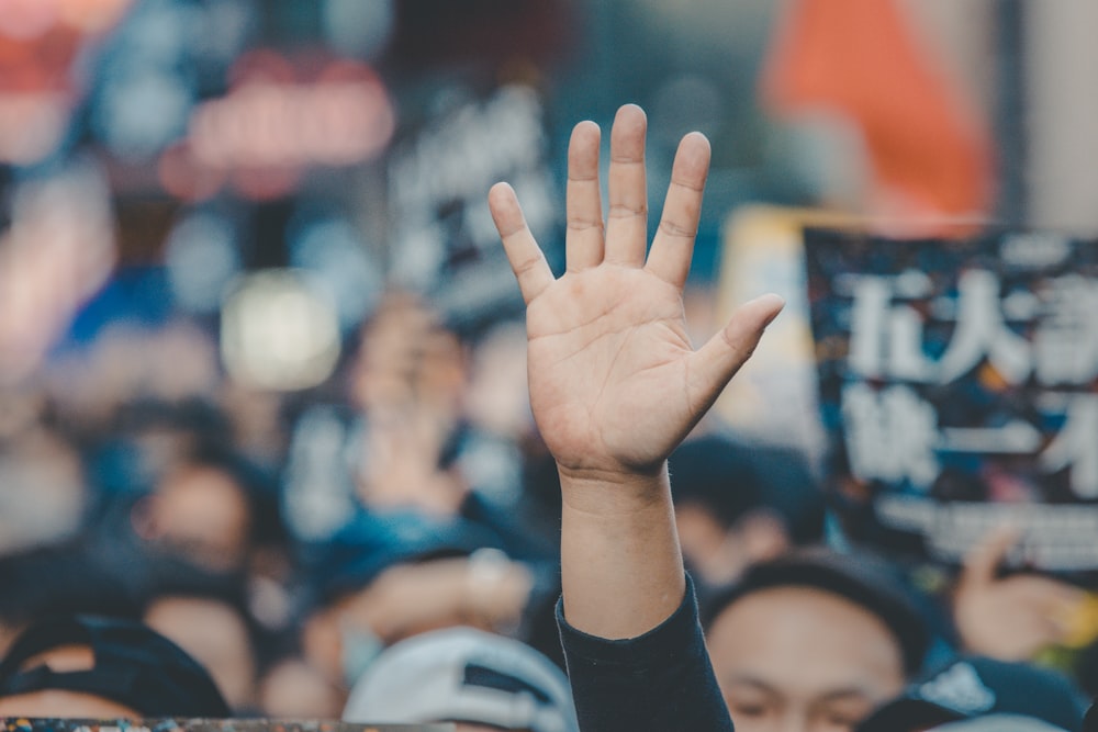 person in black long sleeve shirt showing left hand