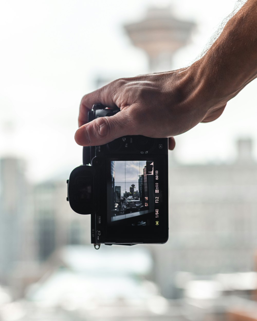 person holding black smartphone taking photo of white building during daytime