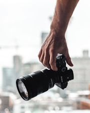 person holding black dslr camera