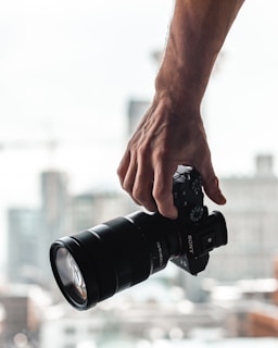 person holding black dslr camera