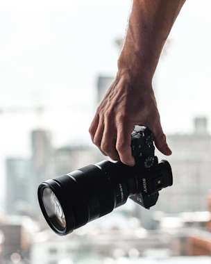 person holding black dslr camera