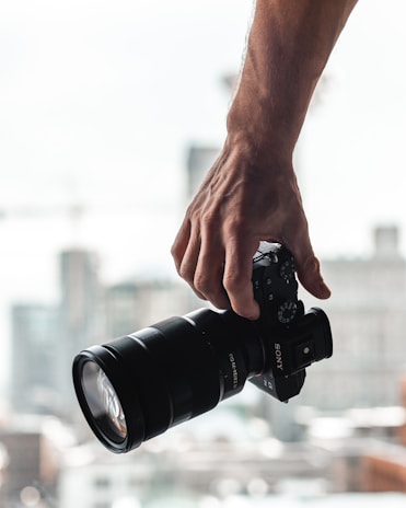 person holding black dslr camera