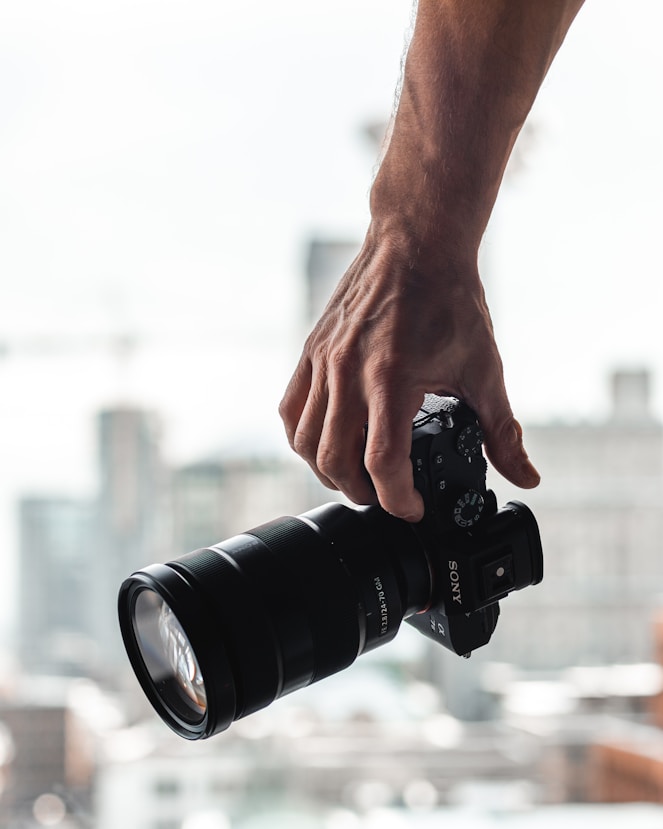 person holding black dslr camera