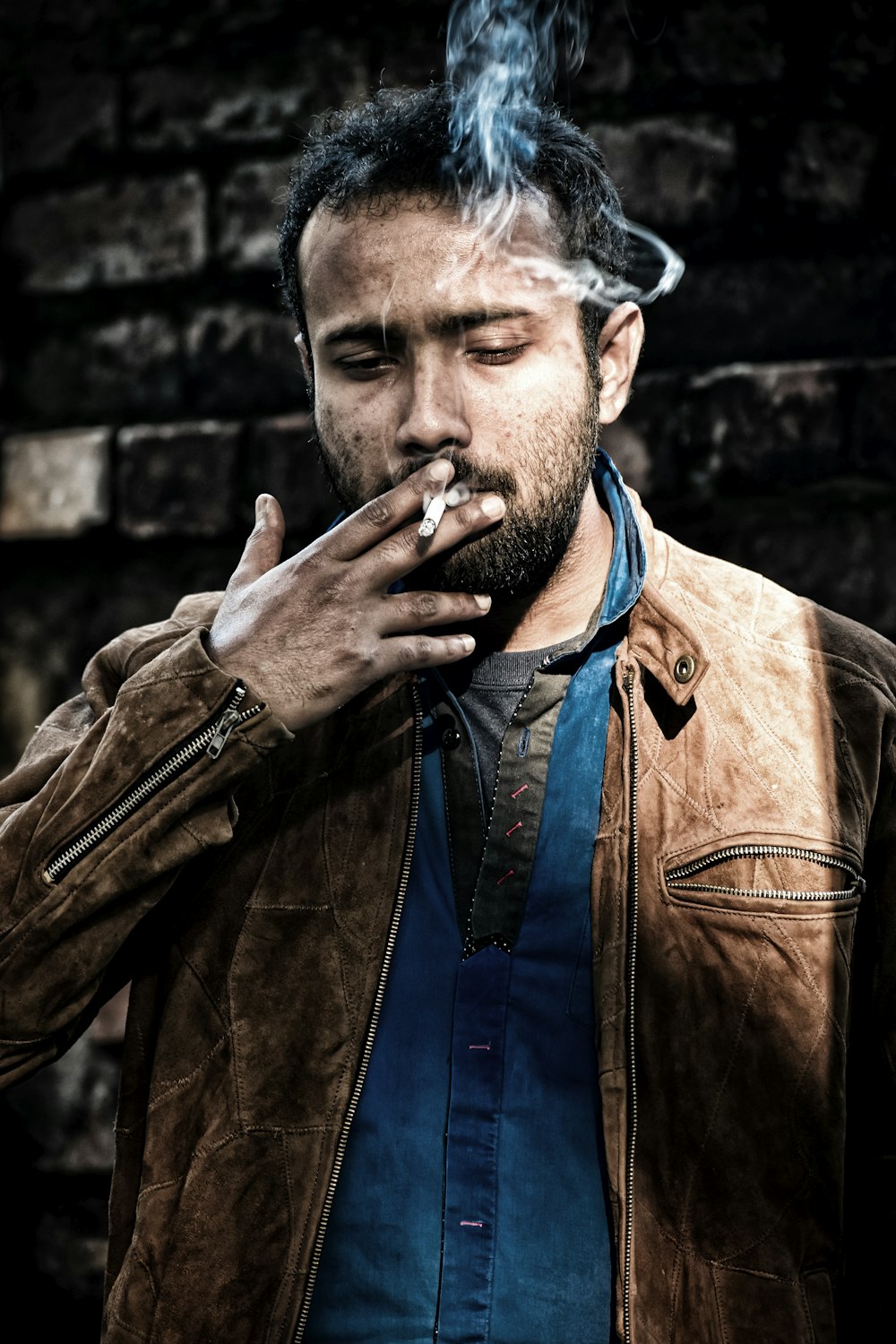 man in brown leather jacket smoking